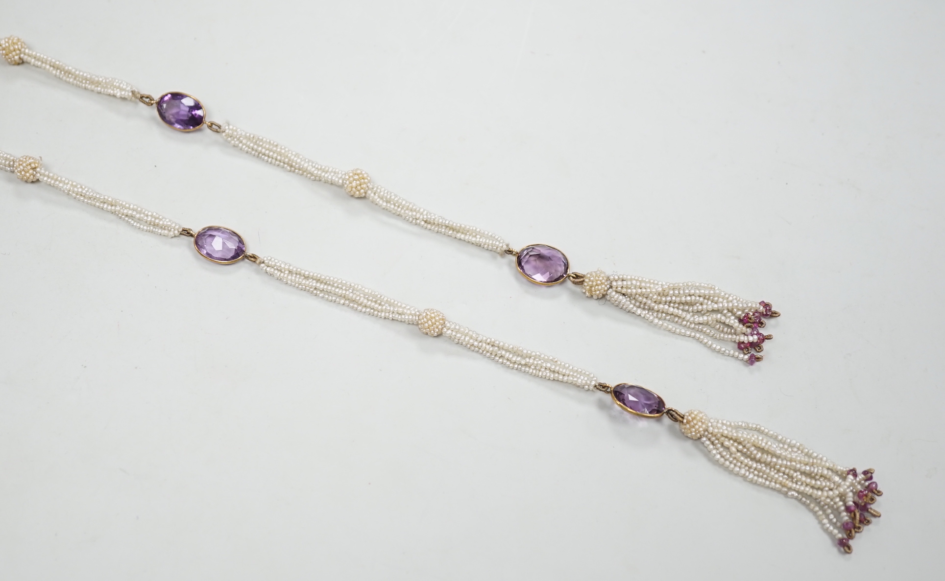 A 19th century Indian multi strand seed pearl and oval cut amethyst set long necklace, with gem set tassel terminals, 170cm.